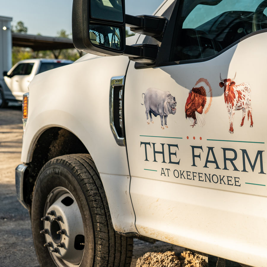 white truck with The Farm at Okefenokee signage on side