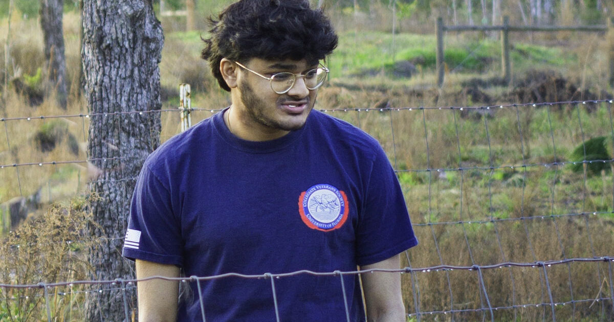 young man with dark hair in a blue shirt