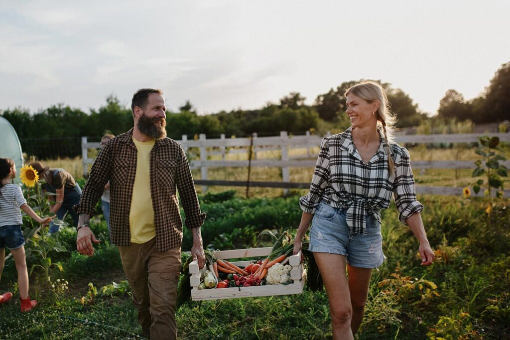 couple carrying bounty of vegetables